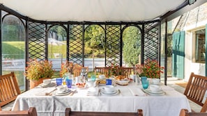 Enjoy al fresco dining in a serene outdoor setting with a beautifully set table and lush green surroundings.