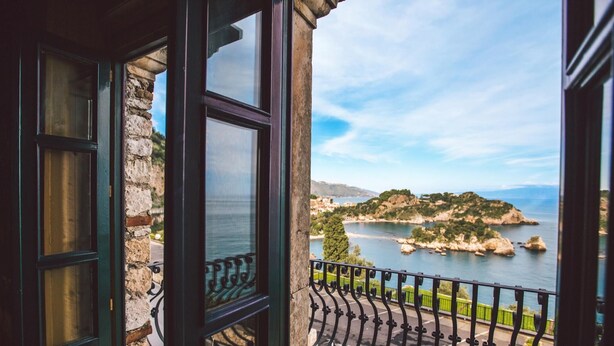 A balcony with a view of a coastal landscape, including a body of water and distant hills. - Torre Pirandello 6 in Taormina (Taormina)