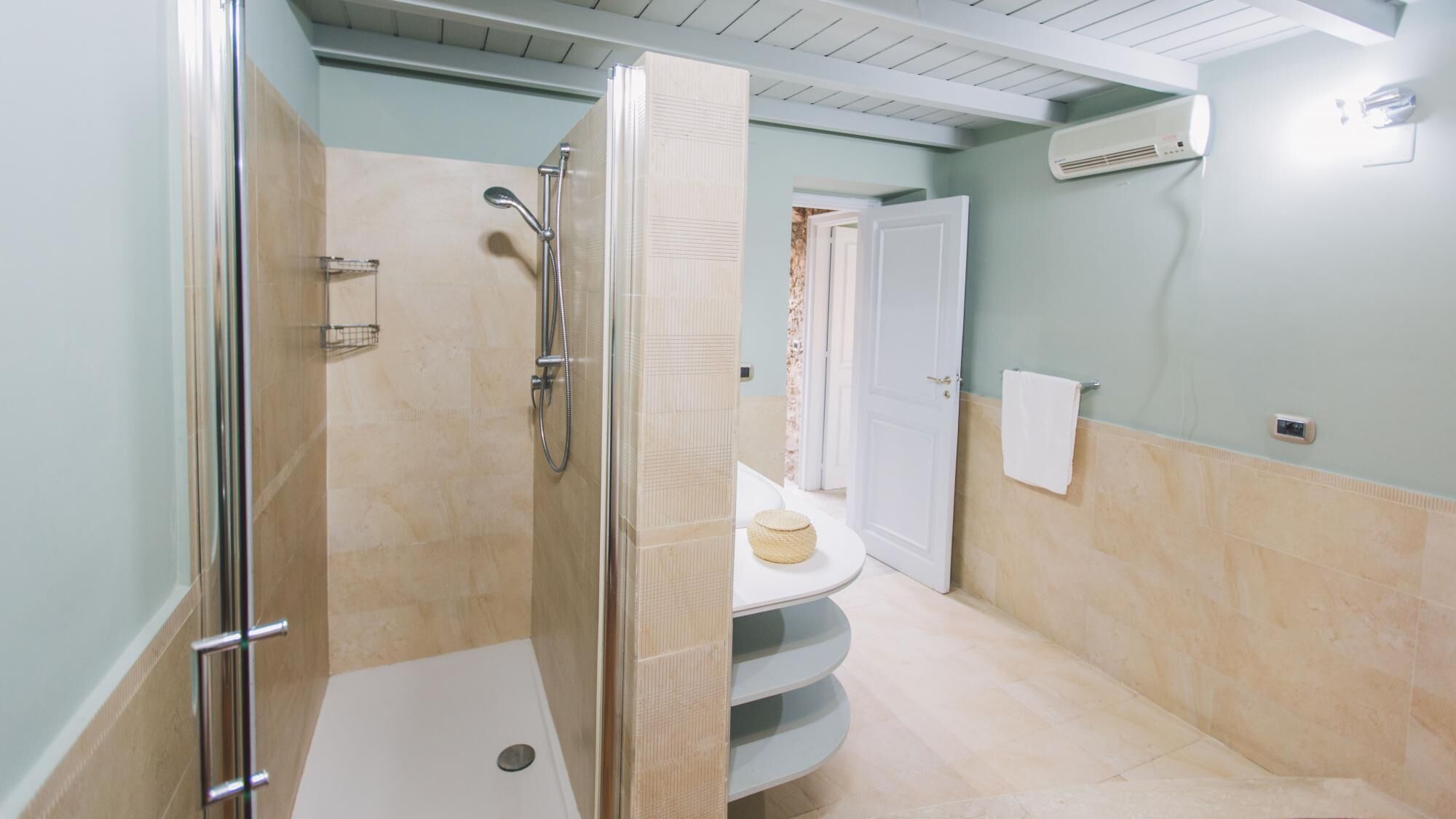 Un baño con ducha de vidrio, lavamanos blanco y retrete.