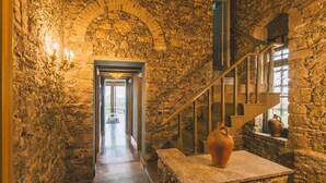 A stone-walled hallway with a staircase leading to a balcony. - Torre Pirandello 6 in Taormina (Taormina)