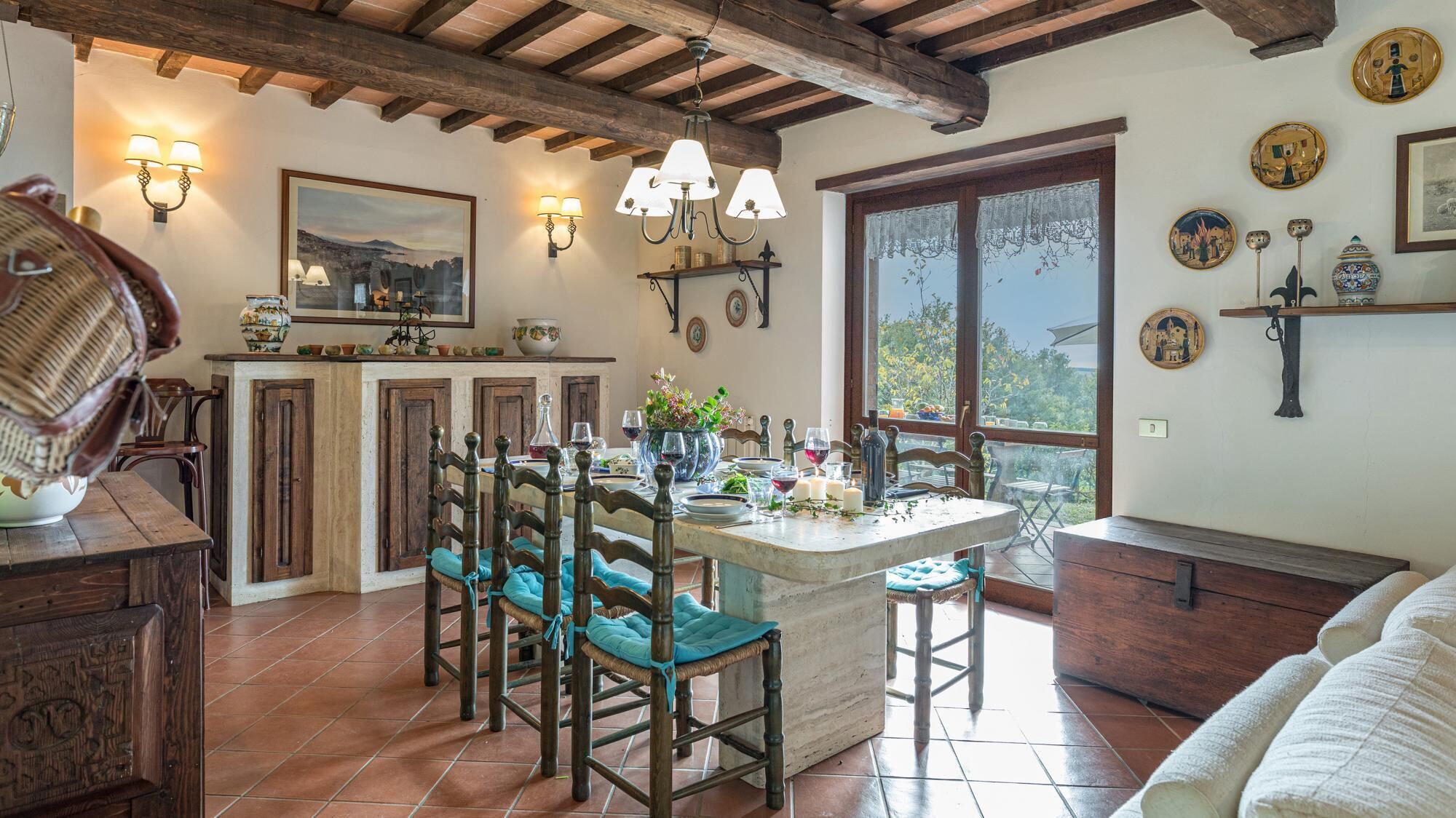 Una cocina rústica con una isla central, sillas de madera y una mesa de comedor.