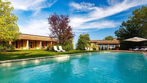 A swimming pool with lounge chairs and a building with a tiled roof. - La Tana del Ghiro 20 (Roncofreddo)