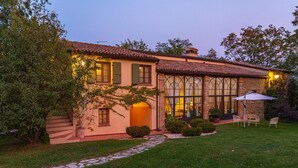 A two-story house with a tiled roof, large windows, and a well-maintained garden. - La Tana del Ghiro 20 (Roncofreddo)
