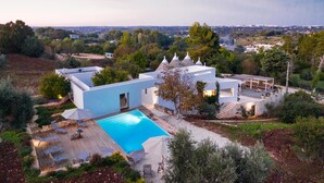 Eine moderne Villa mit Swimmingpool, Außenbereich und Blick auf die umliegende Landschaft.
