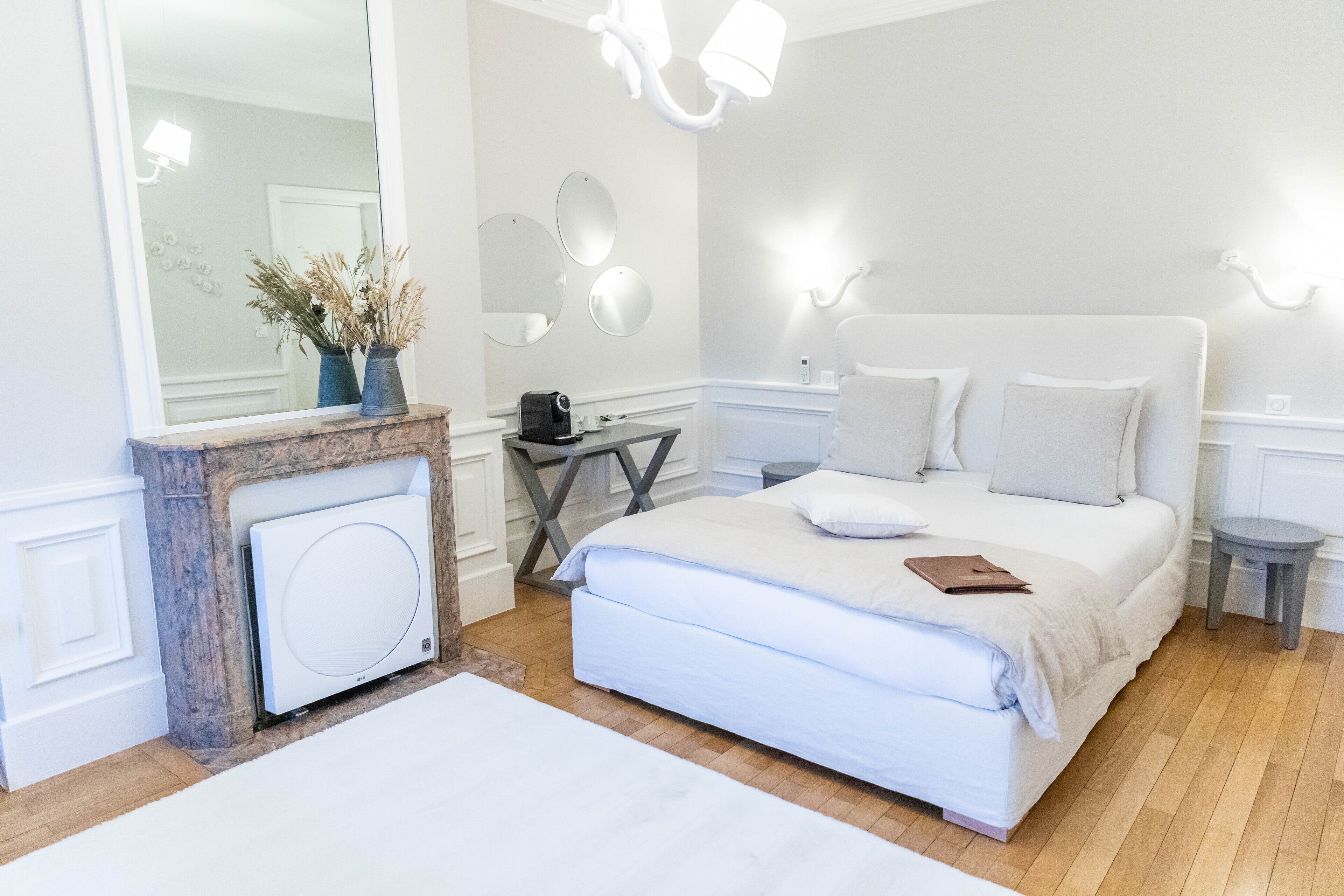 Un dormitorio con una cama grande, un aparador, un espejo y una mesita.