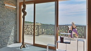 A modern room with a large sliding glass door leading to a balcony with a view of a distant landscape. - Villa Gilda 5 1 in Avola (Avola)