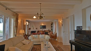 Ein geräumiges Wohnzimmer mit einer Sofagarnitur, einem Couchtisch und einem Fernseher.