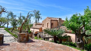 A traditional Mediterranean-style building with a stone pathway leading to the entrance. - Villa Passulunara 14 (Collesano)