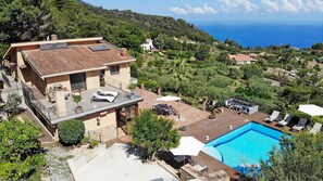 Een villa met een terras op het dak, een zwembad en een prachtig uitzicht op de oceaan.