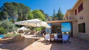 A patio with outdoor seating, a pool, and a view of the ocean. - Villa Provenza 12 4 in Cefal (Cefalù)
