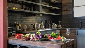 Een moderne keuken met een houten aanrecht, diverse keukenapparaten en een wijnglas.