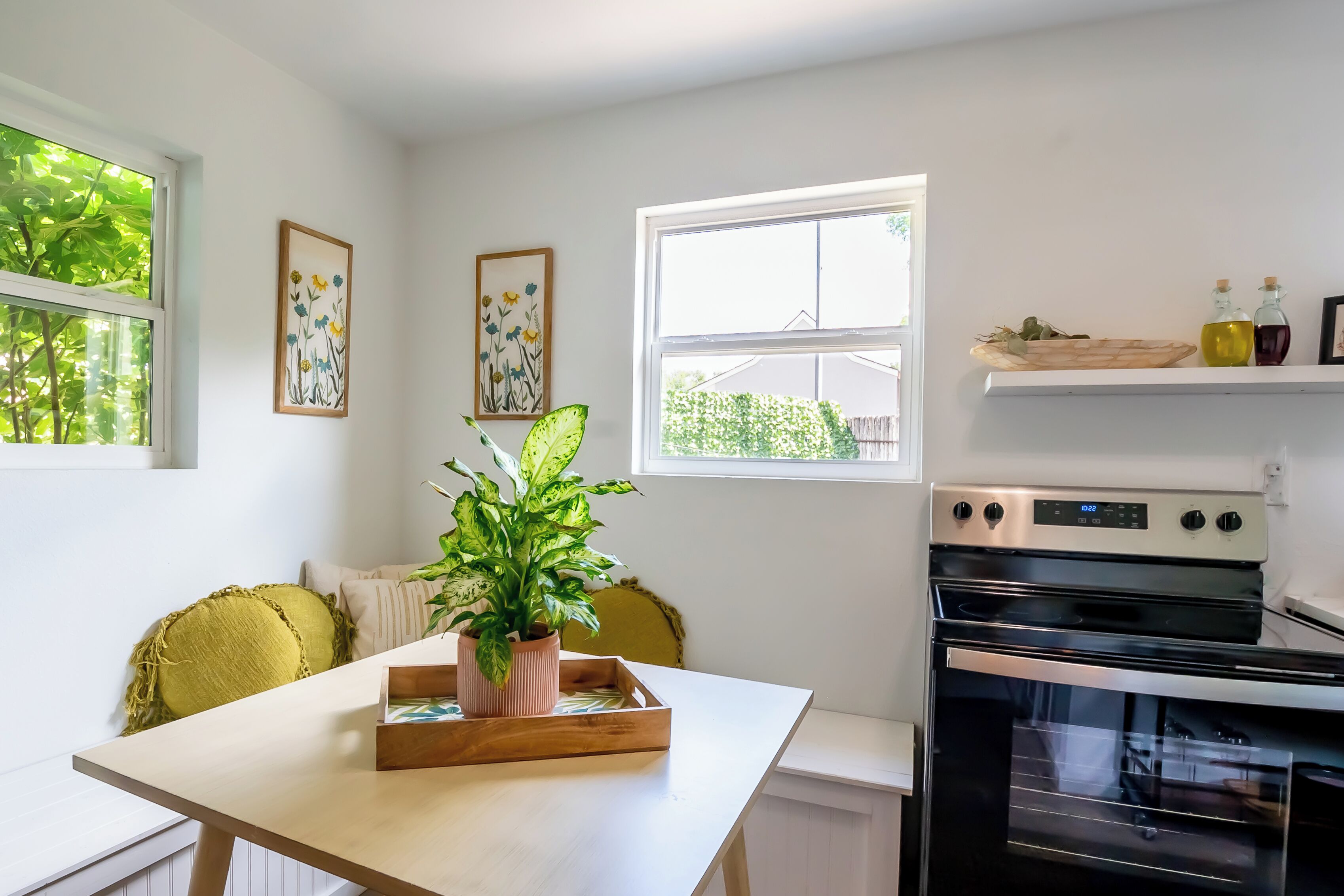 A kitchen with a wooden table, a potted plant, and a built-in oven.