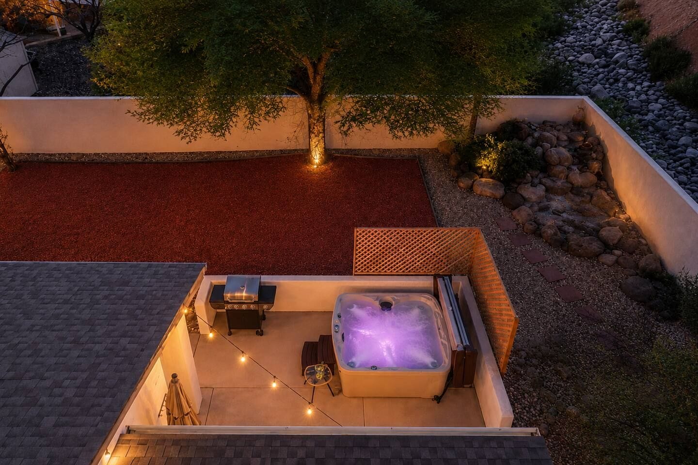 Una terrazza panoramica con vasca idromassaggio, posti a sedere all'aperto e luci decorative.