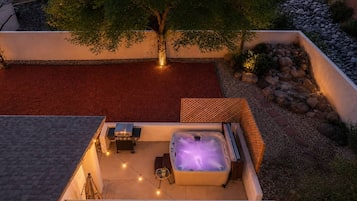 Una terrazza panoramica con vasca idromassaggio, posti a sedere all'aperto e luci decorative.
