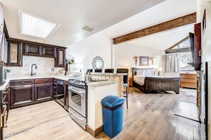 A spacious kitchen with dark wooden cabinets, a large stove, and a blue trash bin. - Silver King 417 | 150 Yards to Lifts | Fireplace | Kitchen | End Unit | Mtn View | Pool & Hot Tub (Park City)