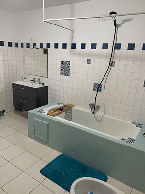 Bathtub, hair dryer, towels, toilet paper