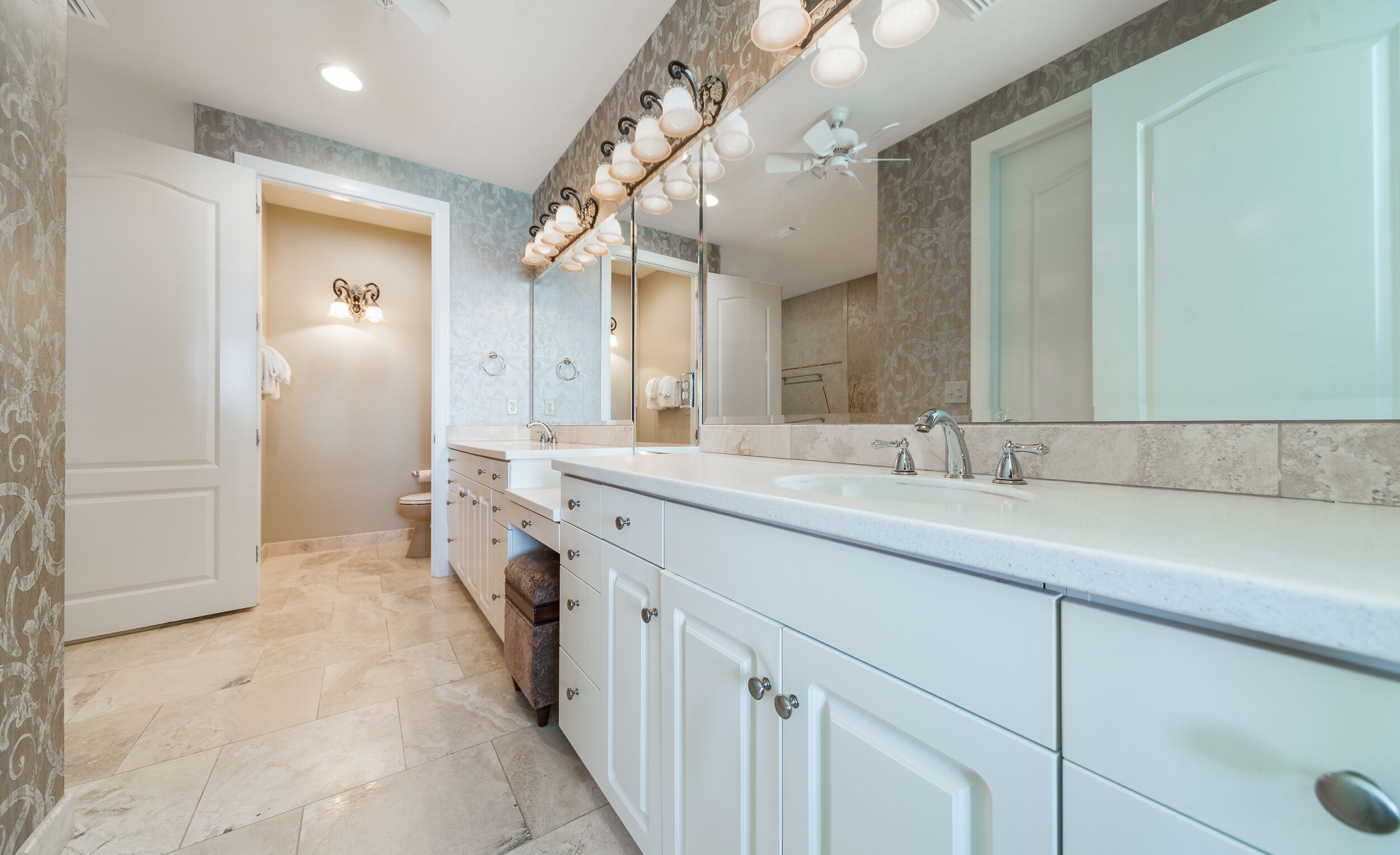 A modern bathroom with a large vanity, a double sink, and a large mirror.