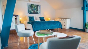 Un dormitorio con cama, mesitas de noche, escritorio y silla.