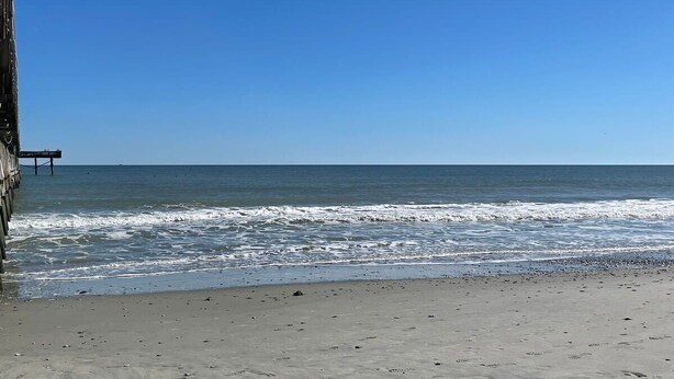 A beach with a pier extending into the ocean. - Fabulous 4 bedroom house in North Myrtle Beach (North Myrtle Beach)