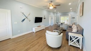 A spacious living room with a ceiling fan, a flat-screen TV, and a dining area with a table and chairs. - Fabulous 4 bedroom house in North Myrtle Beach (North Myrtle Beach)