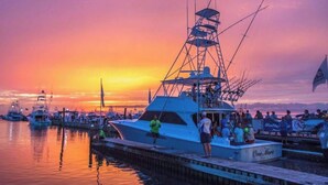 A docked yacht with a crew, surrounded by other boats, during sunset. - Castaway Cottage- Lakefront & golf cart included! (Miramar Beach)