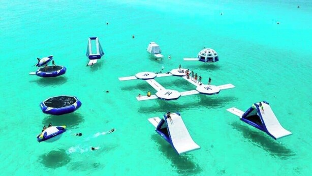A floating platform with various watercraft and people. - Castaway Cottage- Lakefront & golf cart included! (Miramar Beach)