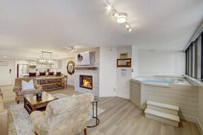 Ein modernes Wohnzimmer mit Kamin, Whirlpool und Essbereich.
