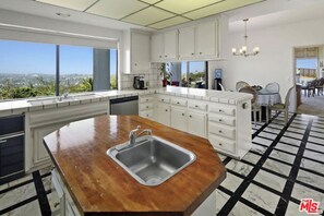 Enjoy a city view from the kitchen, where a central island and white cabinetry meet.