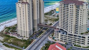 A high-rise hotel with multiple floors, a beach view, and a parking garage.