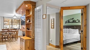 Un dormitorio con cama, cabecera de madera y vistas a un paisaje montañoso.