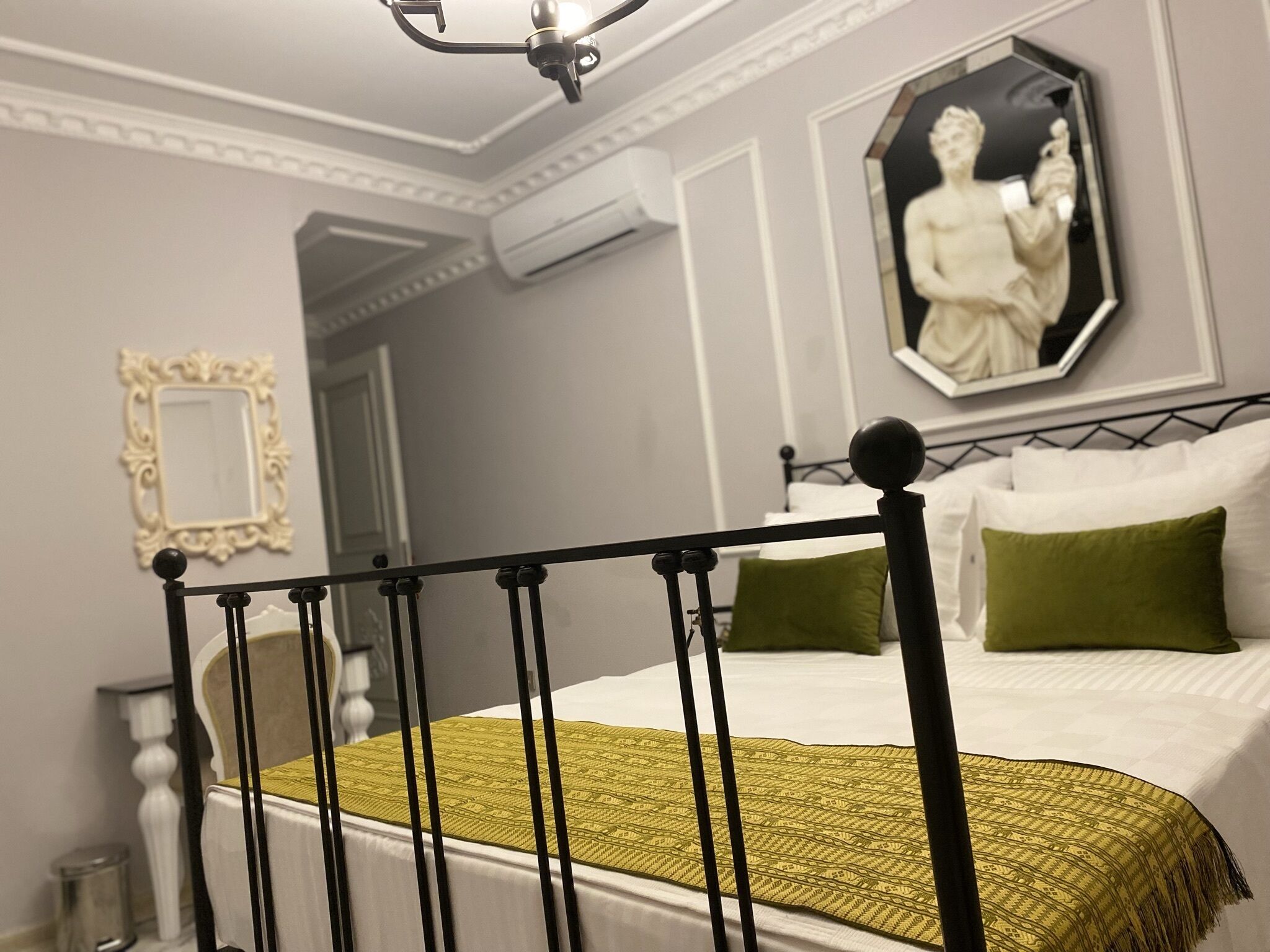 Quarto com cama, espelho e ventilador de teto.