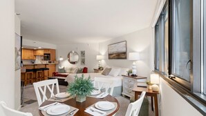 Una sala moderna con comedor, cocina y un ventanal grande.