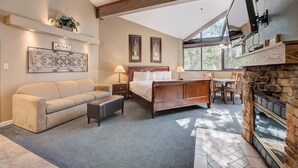 A spacious bedroom with a large bed, a sofa, a fireplace, and a dining area. - Silver King 416 | 150 Yards to Lifts | Fireplace | Kitchen | Mountain View | Pool & Hot Tub (Park City)
