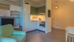 A compact living space with a sofa, kitchenette, and a dining area.