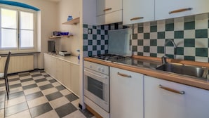 A kitchen with a checkered floor, a stove, oven, and a sink.