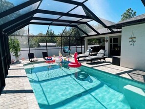 A covered swimming pool with lounge chairs and inflatable toys. - Memorable Monavilla 5 Miles From Beach! (Englewood)