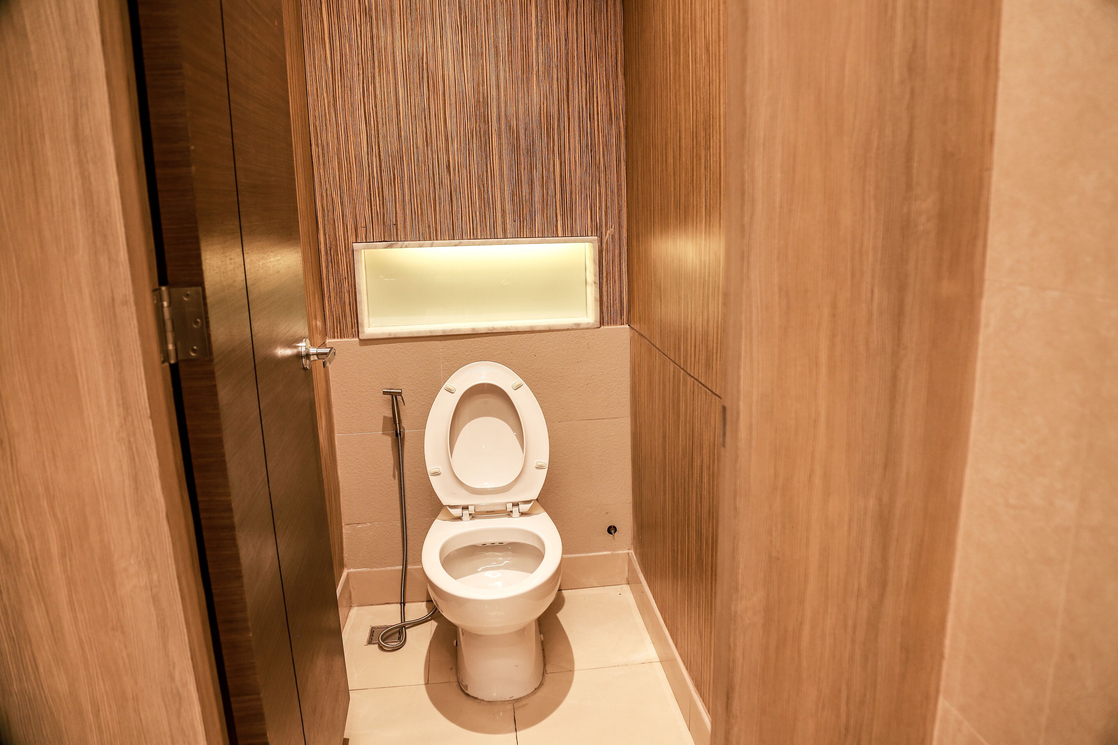 Ein modernes Badezimmer mit Toilette, Handtrockner und spiegel. 