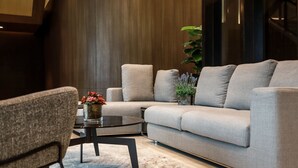 Un salon moderne avec un canapé gris, une table basse ronde et un fauteuil gris.