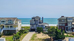 A beachfront property with multiple houses, a driveway, and a view of the ocean. - Lofty View ☀️ Semi-Oceanfront 4 BR home, Dog-Frendly 🐕 & Private Pool (Duck)