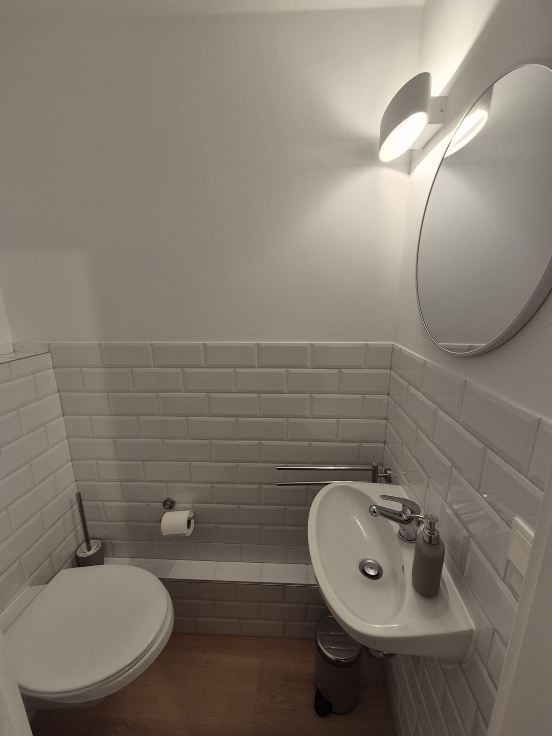 Ein Badezimmer mit Toilette, Waschbecken und Spiegel.