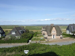 Een kustdorp met traditionele stenen huizen, een heldere lucht en uitzicht op zee.