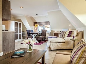 Een moderne loft met woonruimte, een eethoek, een bank en een salontafel.