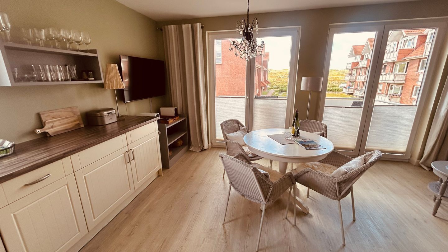 Une cuisine moderne avec un coin repas, un téléviseur et un balcon offrant une vue agréable.