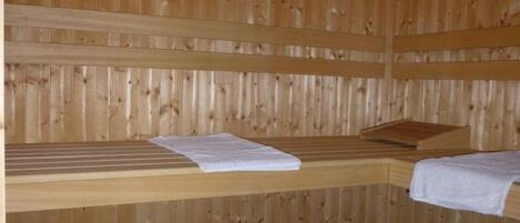 A sauna room with wooden walls and benches.