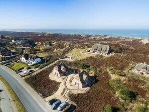 An aerial view of a coastal area with several houses and a road.