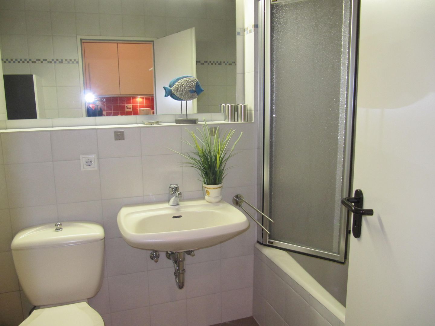 A bathroom with a toilet, sink, and shower.
