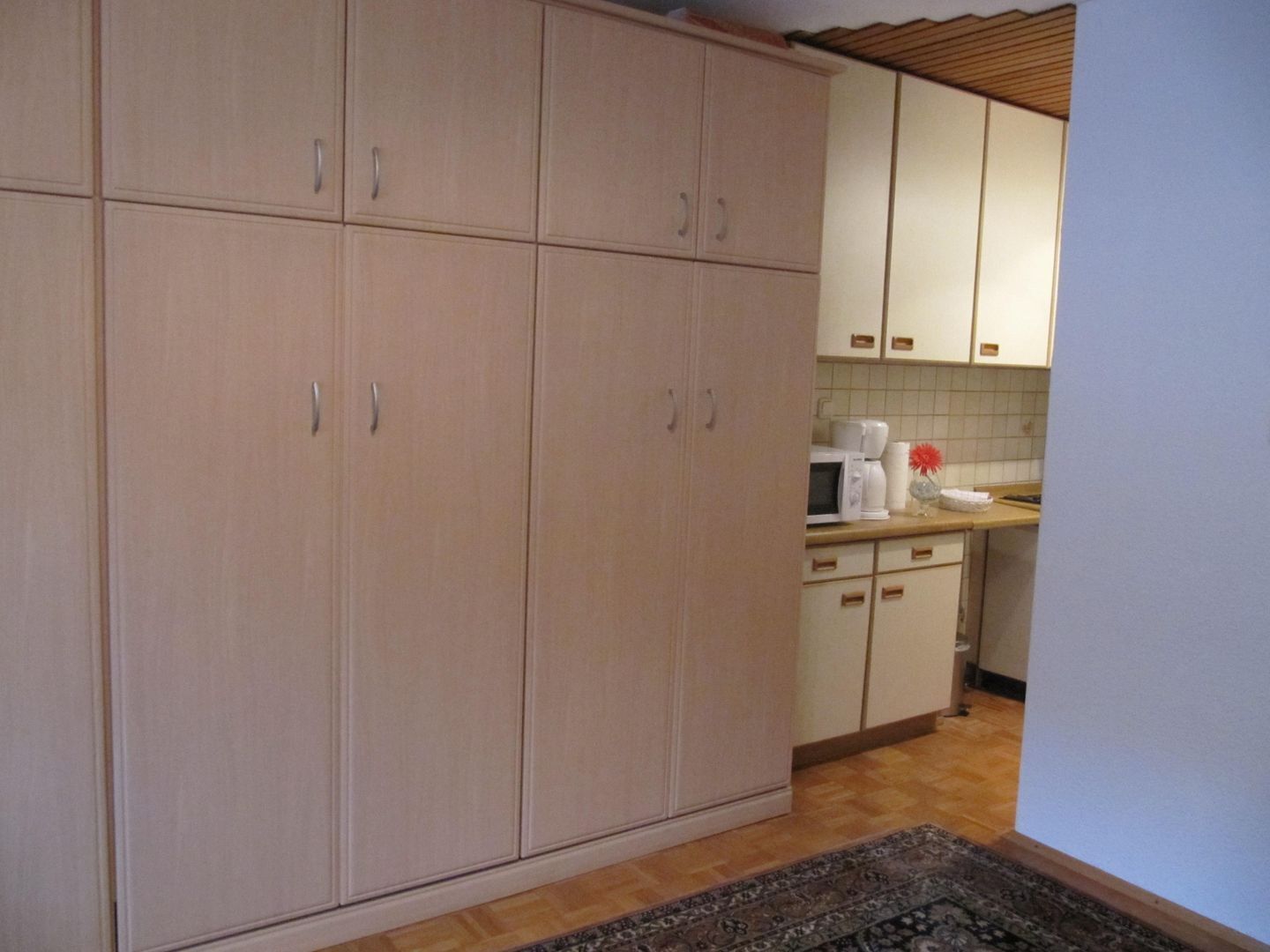 A kitchen with cabinets, a microwave, and a coffee maker.