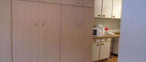 A kitchen with cabinets, a microwave, and a coffee maker.