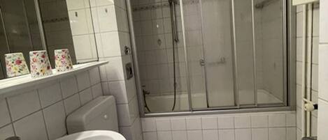 Ein Badezimmer mit Toilette, Waschbecken und Duschkabine.