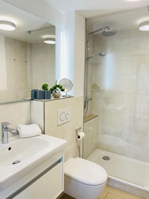 Un bagno moderno con doccia, servizi igienici e lavandino.